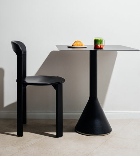 Ein Rey Stuhl der Marke HAY und ein Cone Table der Marke HAY stehen auf grauen Fliesen. Ein Matcha steht auf dem Tisch.